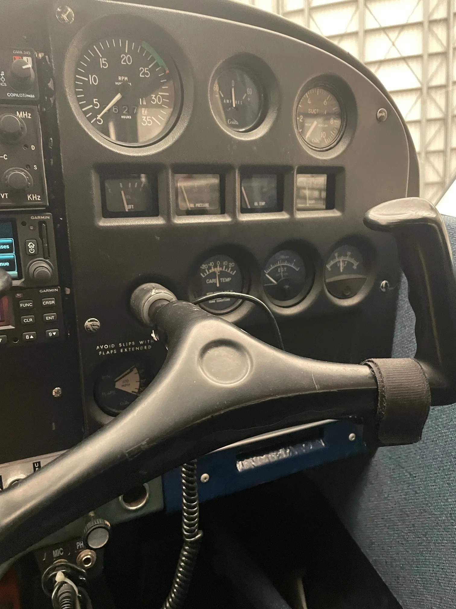 Close-up view of an aircraft's instrument panel with gauges and a black control yoke.