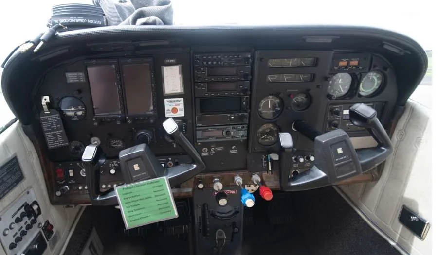 The instrument panel of a small aircraft, featuring various gauges, radios, and controls.