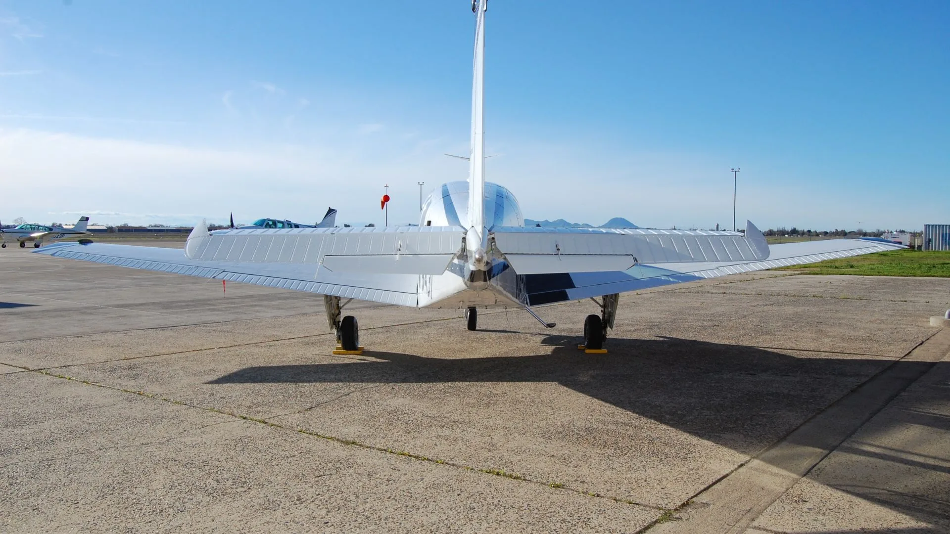 Rear view of a Beechcraft Bonanza parked on the tarmac.