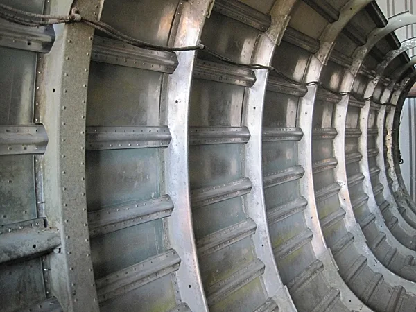 Close-up side view of an aircraft fuselage section's internal structure with ribs and skin panels.