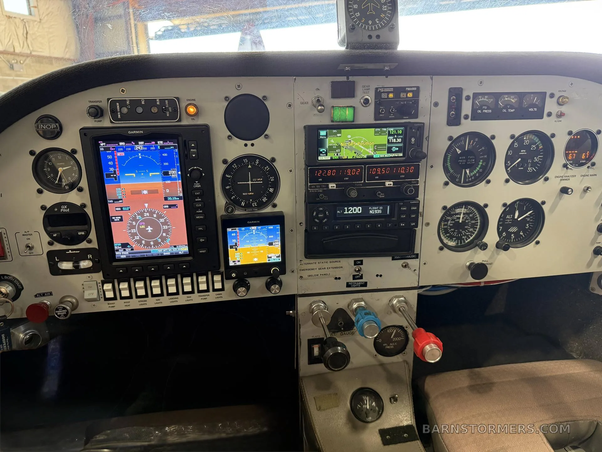 The aircraft's cockpit instrument panel features a mix of analog gauges and modern Garmin digital displays.