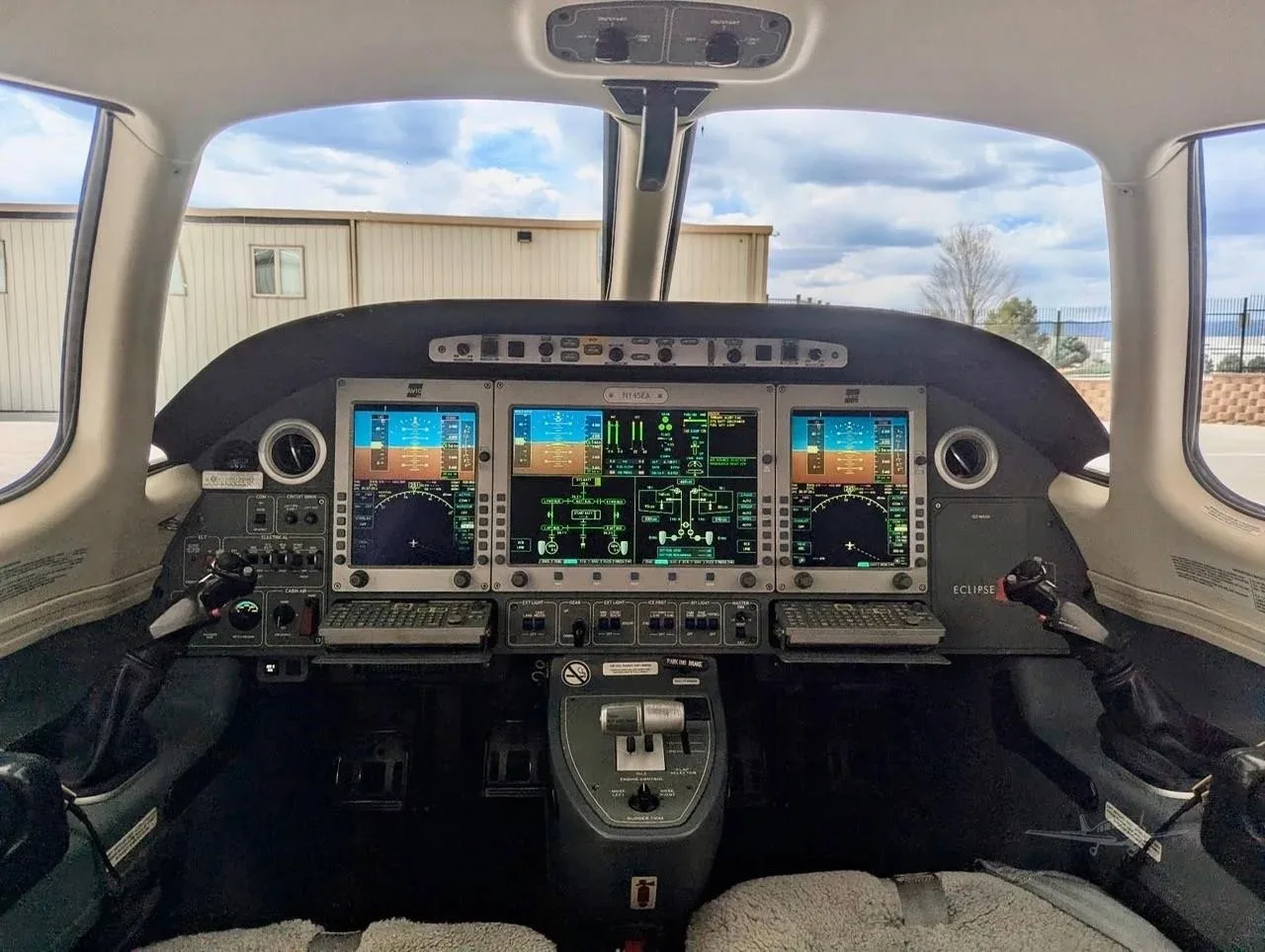 The cockpit of an Eclipse jet, showing the multi-function displays and control yokes.