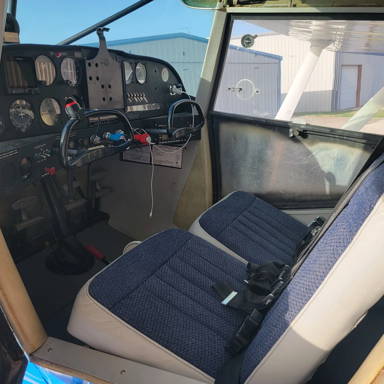 The cockpit of the Maule aircraft, showing the instrument panel, controls, and front seats.