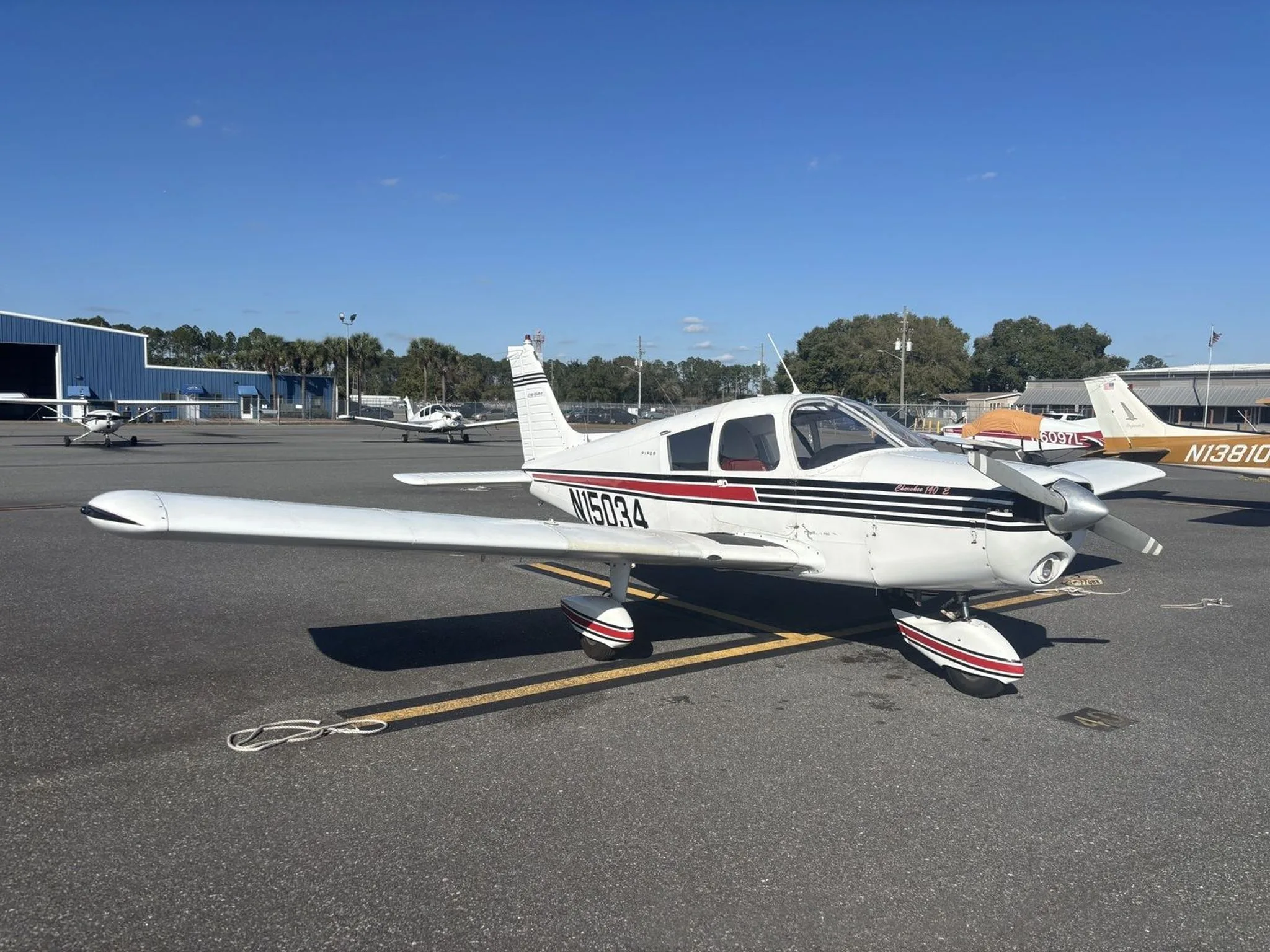 Side view of the Piper Cherokee 140 at an airport.
