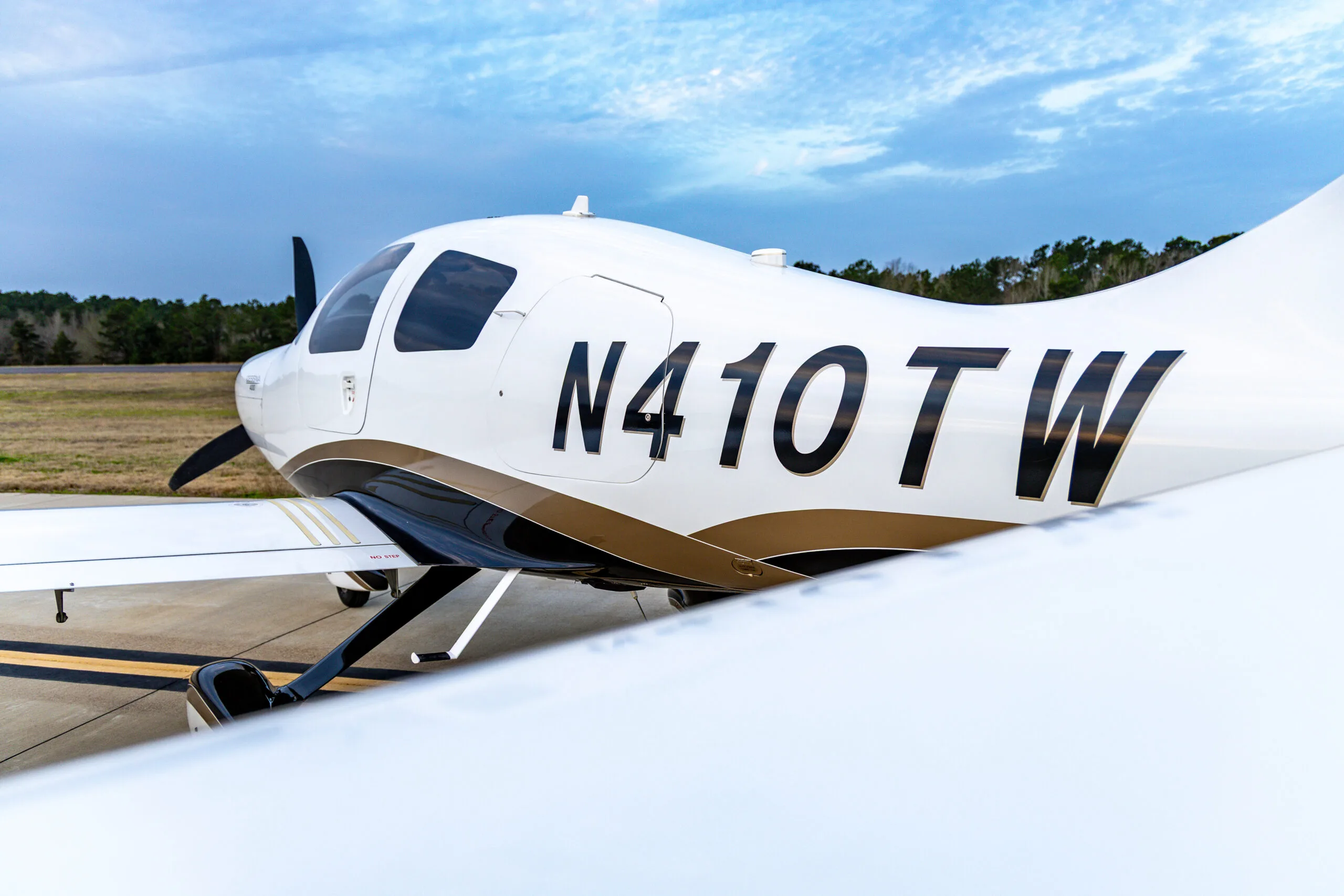 Close-up of the side of a Cessna 400, registration N410TW, parked on the tarmac.
