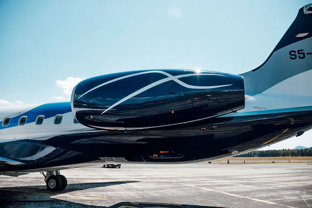 A close-up of the dark blue engine and tail section of an Embraer ERJ 145, showing the "S5-" registration.