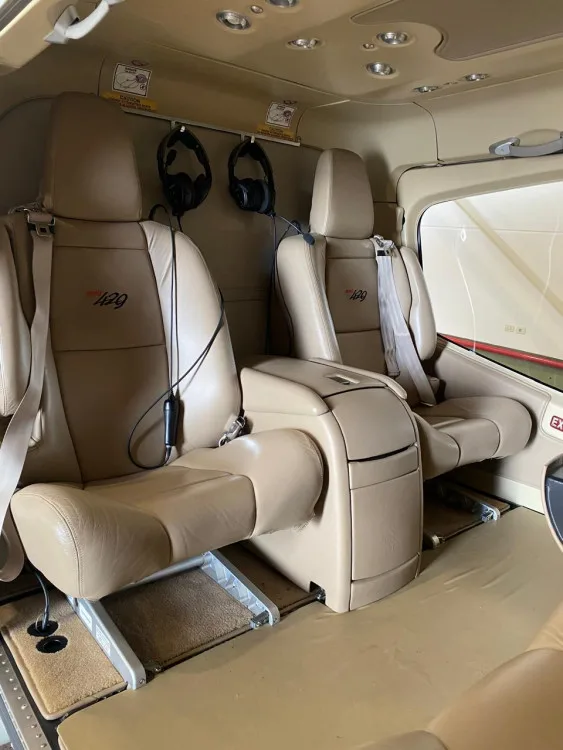 Two tan leather passenger seats with "429" embroidered on them, inside the Bell 429 helicopter cabin.