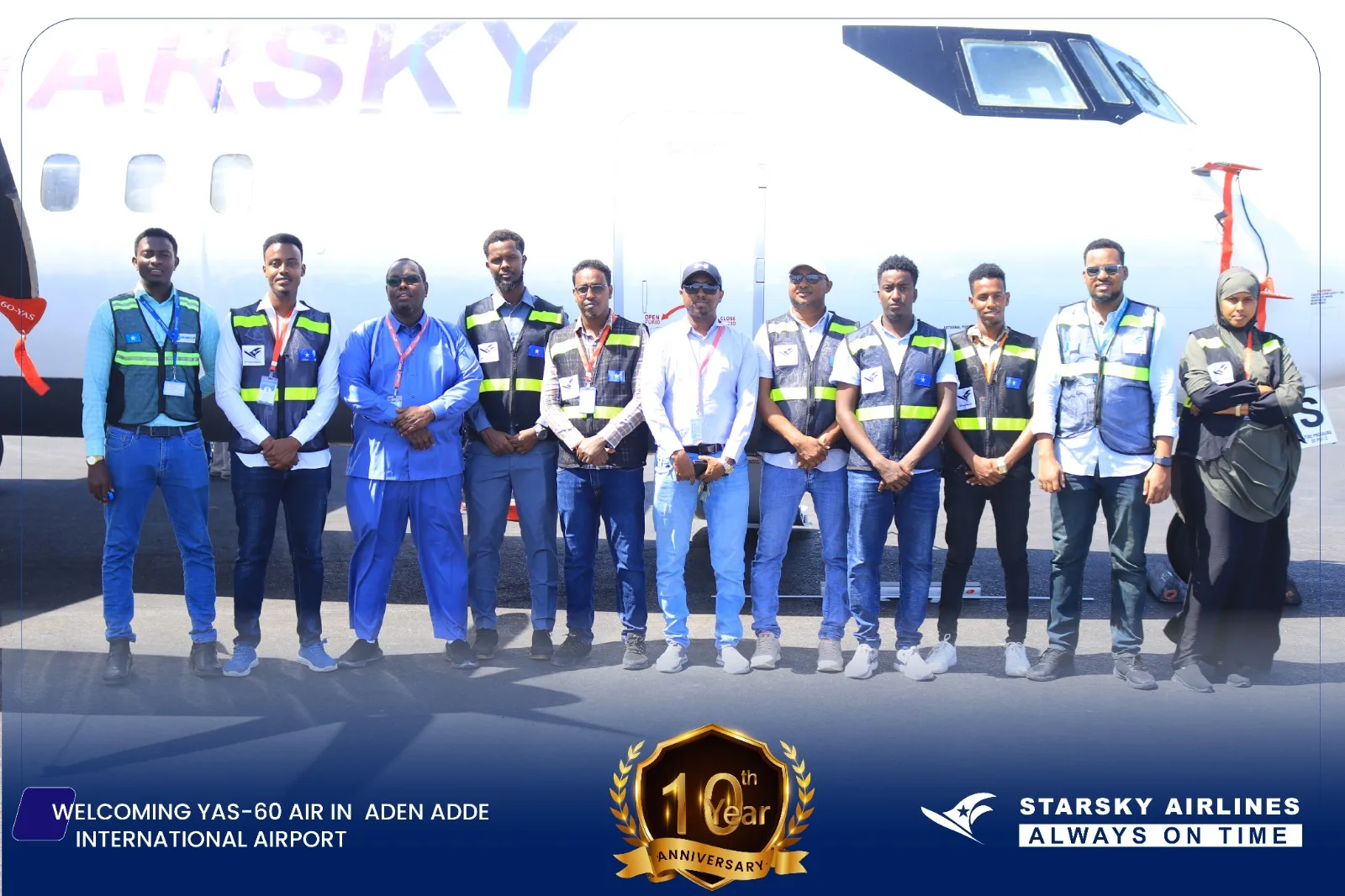 A group of airline staff stands in front of a white Starsky Airlines aircraft on the tarmac at Aden Adde International Airport.