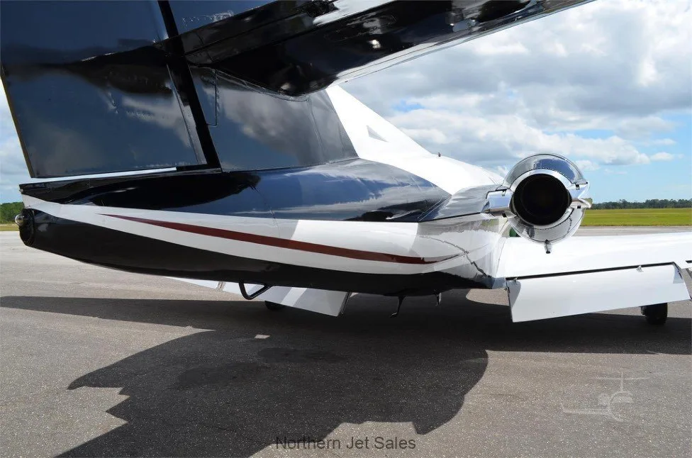 Rear view of a white and black jet on the tarmac.