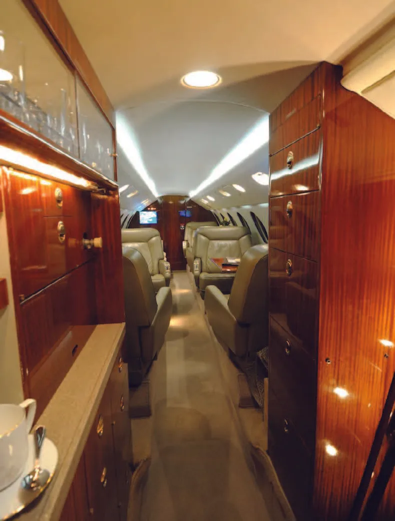 View of the aircraft's cabin interior with wood paneling and leather seats.