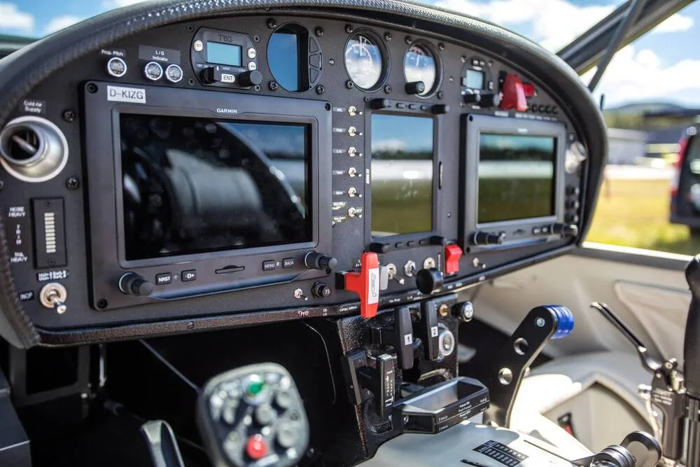 The cockpit instrument panel of a Stemme S12 motorglider, showing multiple Garmin displays and controls.