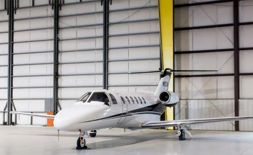 A white and black Cessna Citation business jet, tail number N507VV, parked inside a hangar.