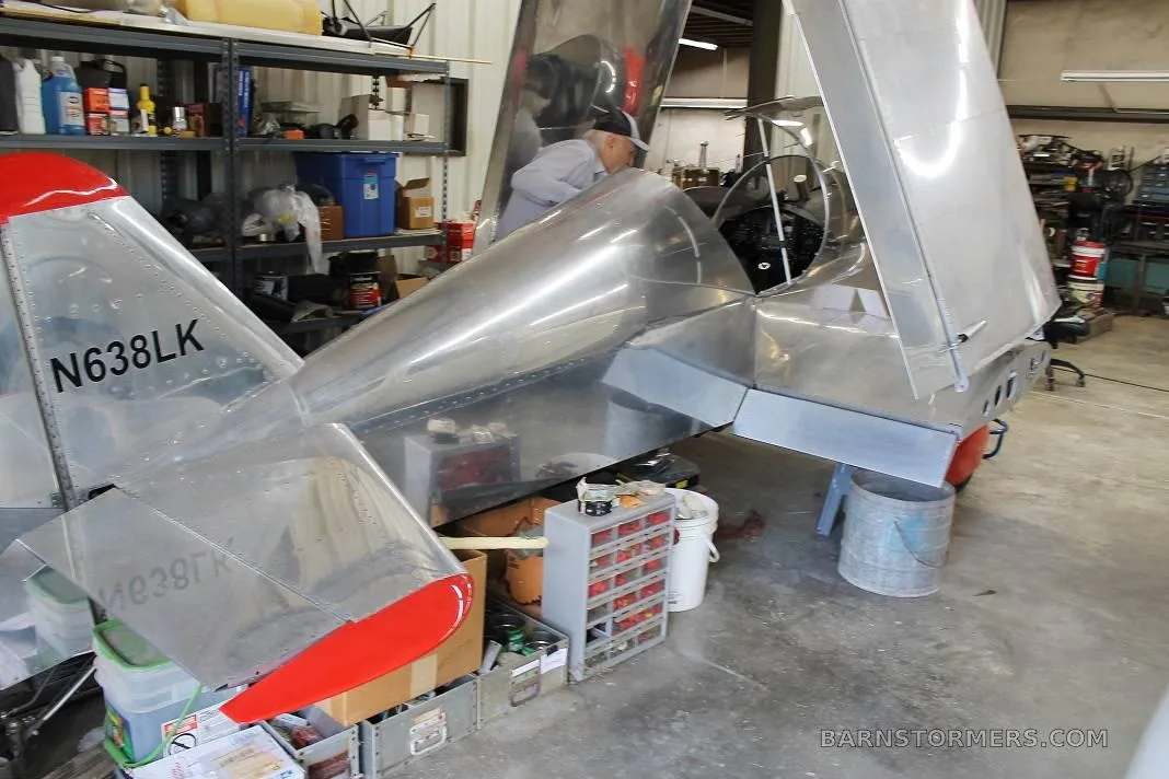 The silver tail section of an experimental aircraft, registration N638LK, with red accents is visible in a workshop.