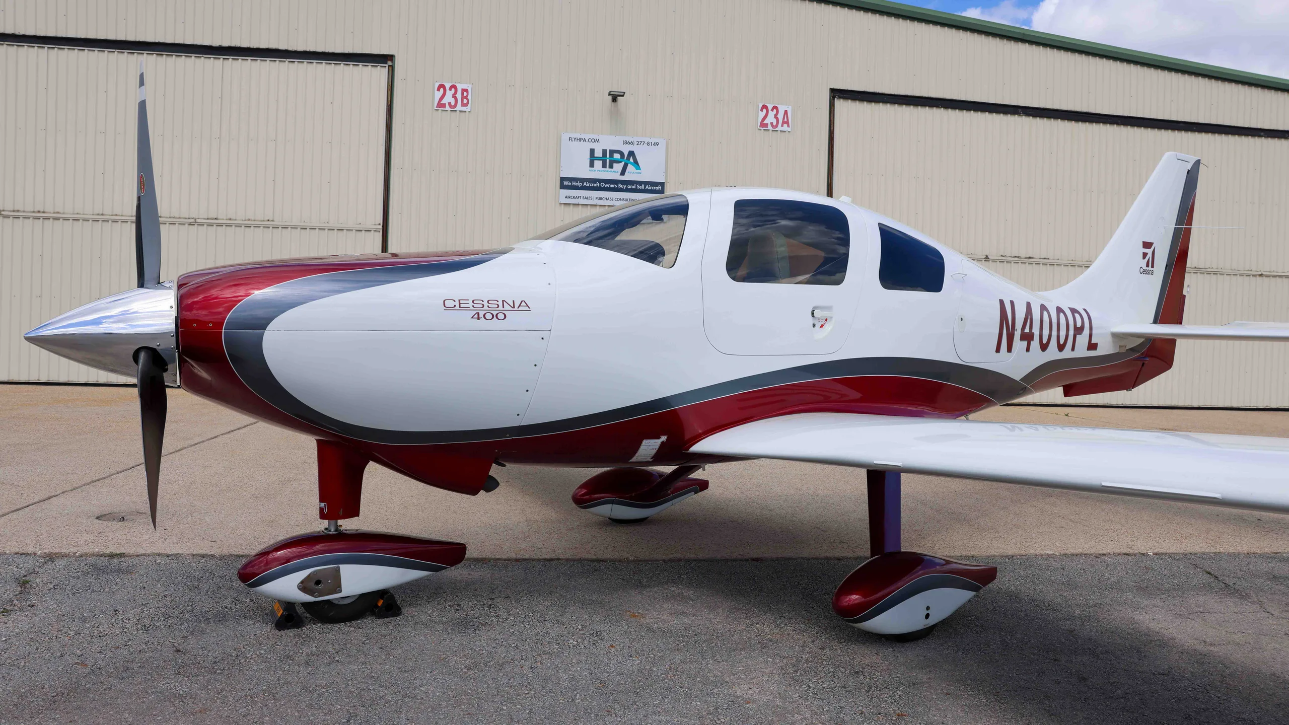 A close-up view of the front fuselage and propeller of the white and red Cessna 400, N400PL.
