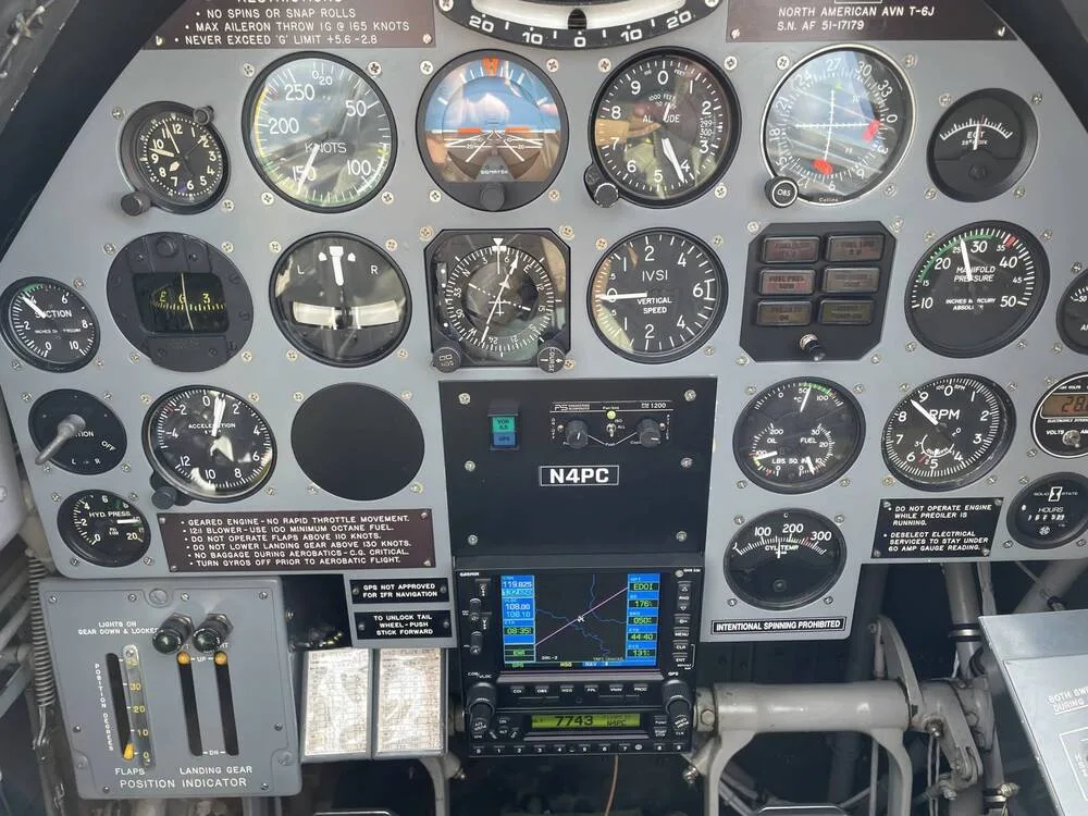 A detailed view of the instrument panel in the cockpit of a North American T-6 Texan, displaying various gauges and the "N4PC" registration.