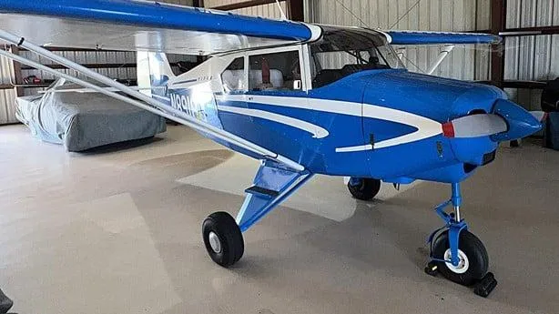 Front-right view of a blue and white single-engine aircraft, N8918D, in a hangar.