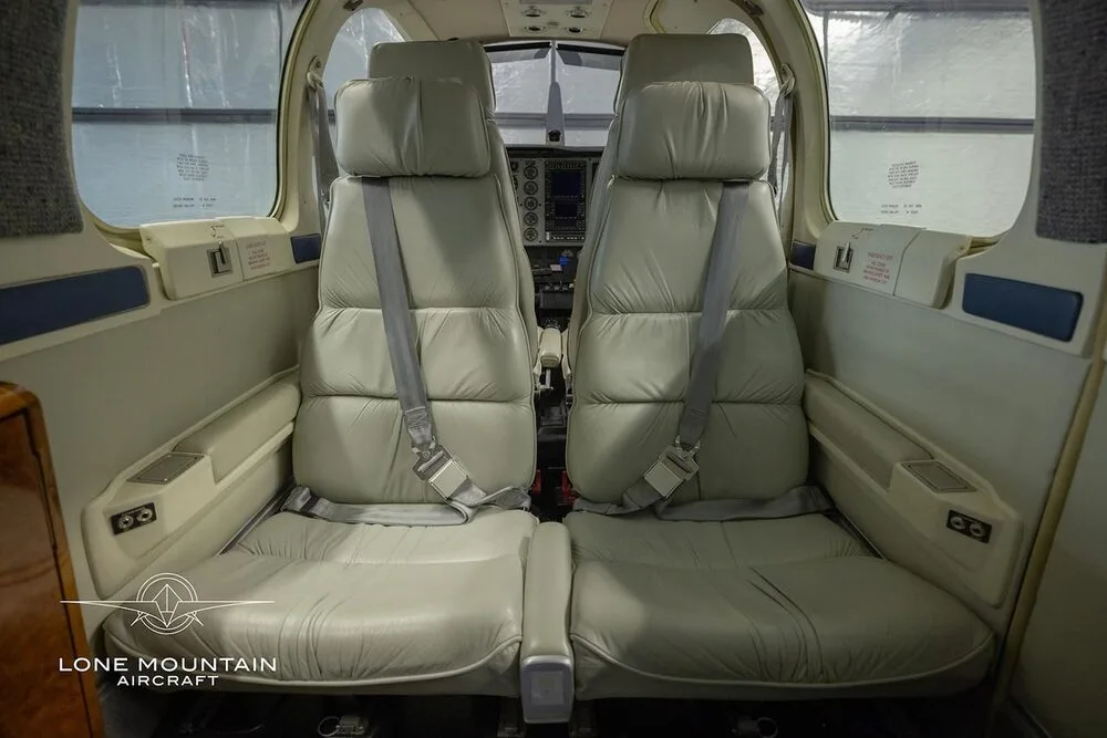 The light gray leather passenger seats in the cabin of a Beechcraft Bonanza A36.