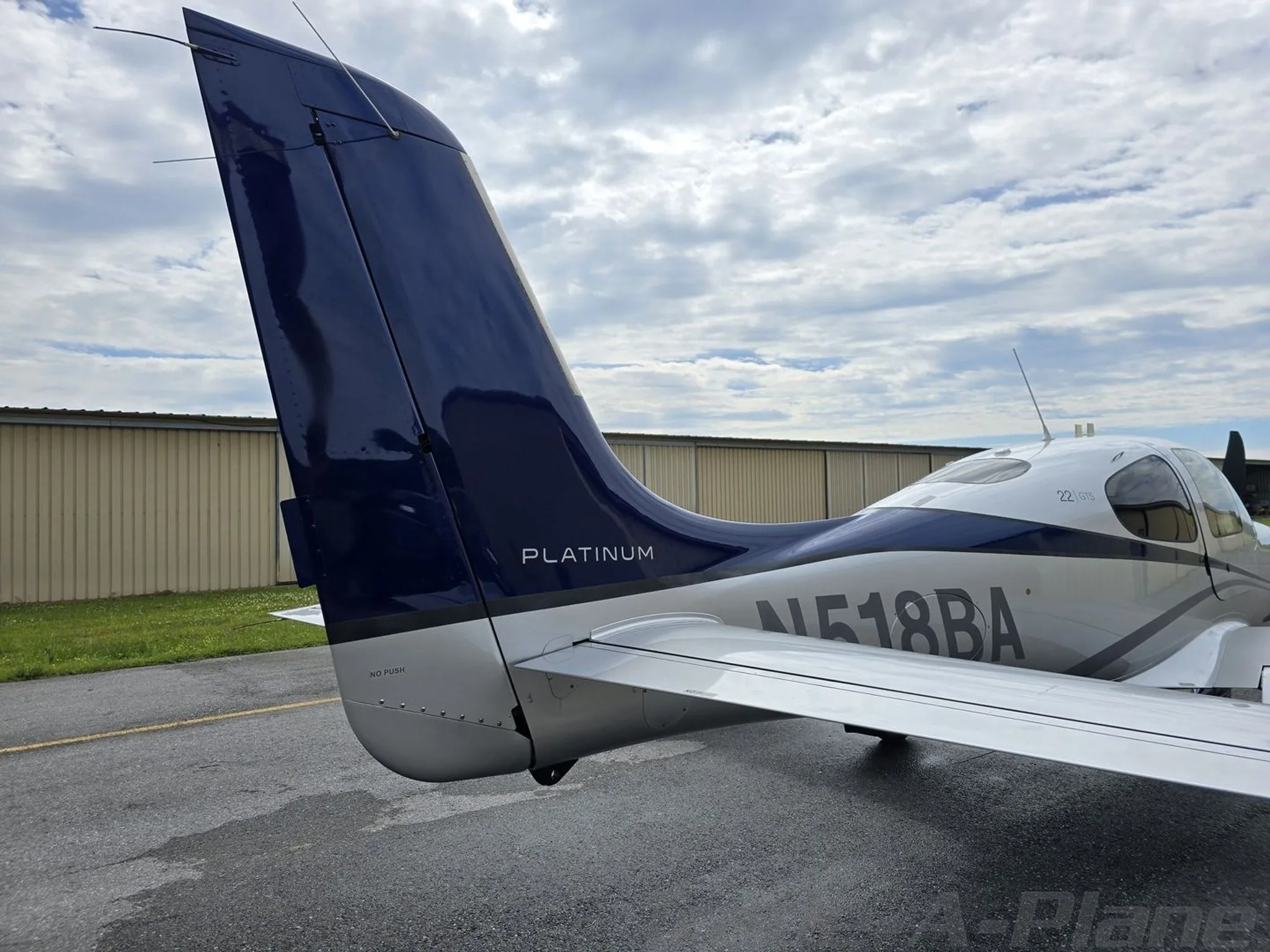 Rear-side view of the blue and silver tail of a Cirrus SR22T aircraft, with 'PLATINUM' text visible.