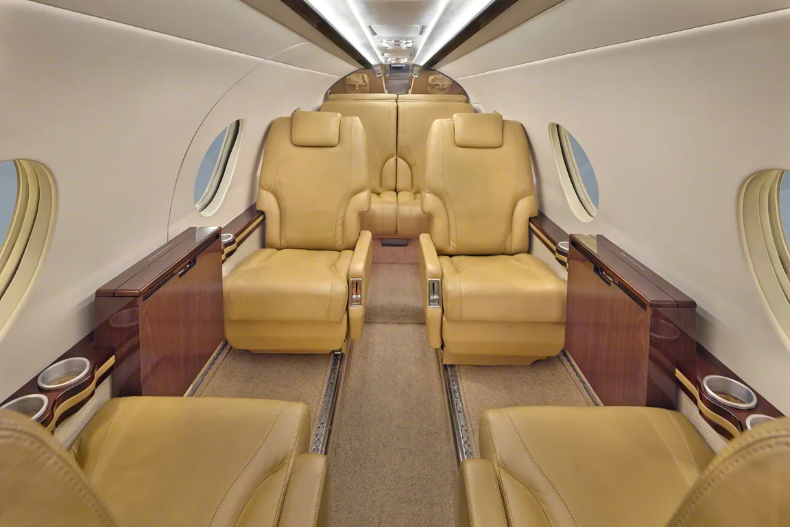 Interior view of the aircraft cabin with tan leather seats.