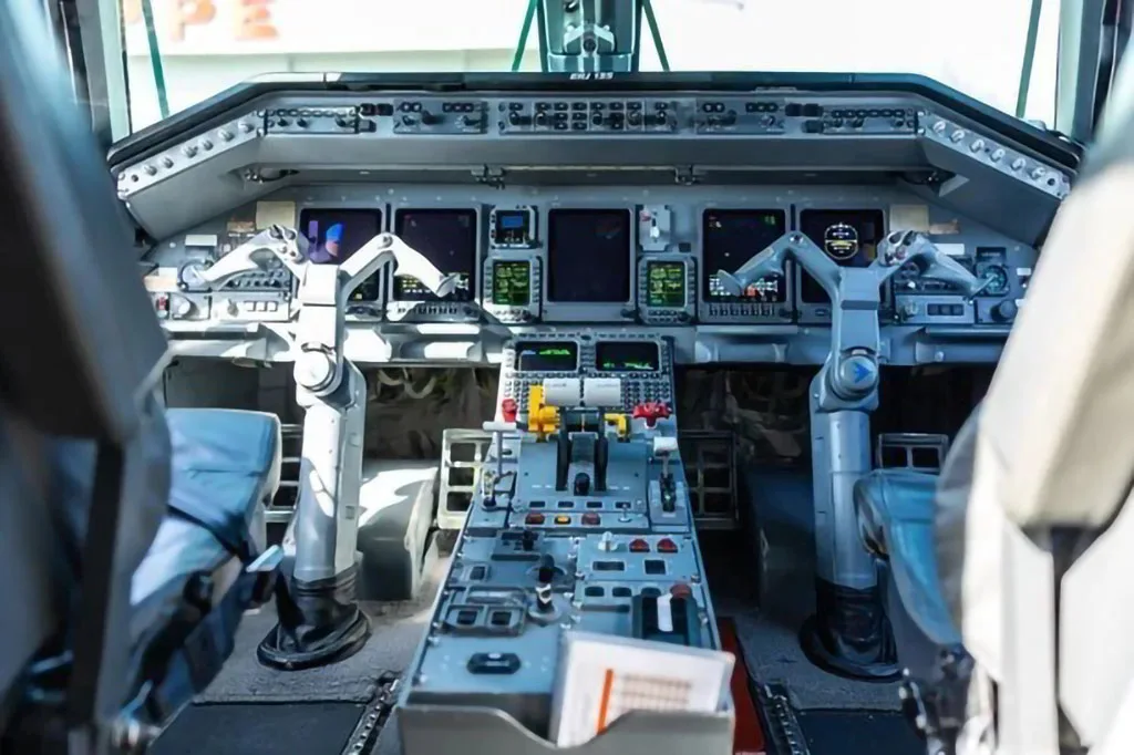 The detailed instrument panel and controls of an aircraft cockpit are shown from the pilot's perspective.