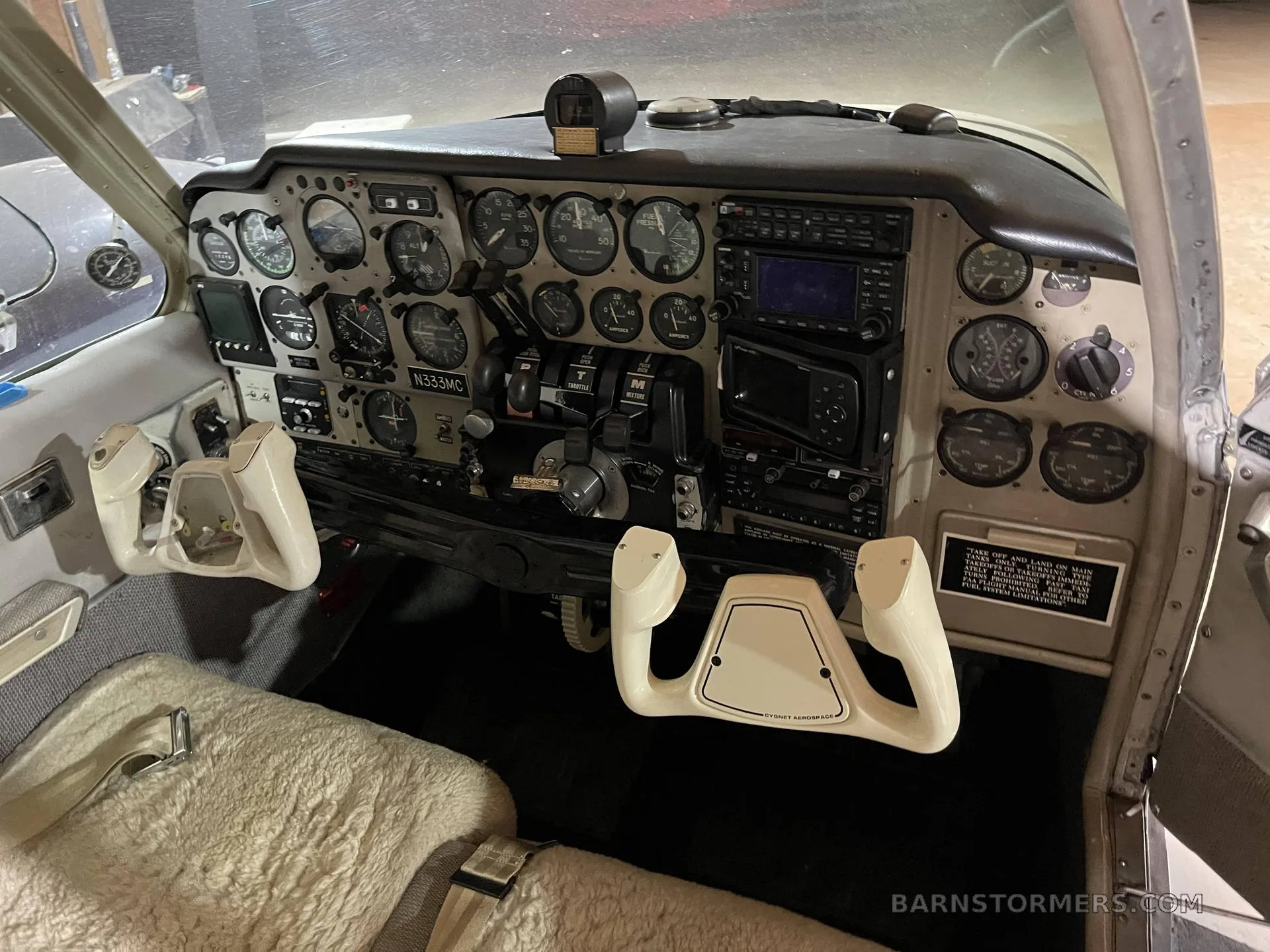 The cockpit instrument panel of a twin-engine aircraft, showing gauges, avionics, and control yokes.