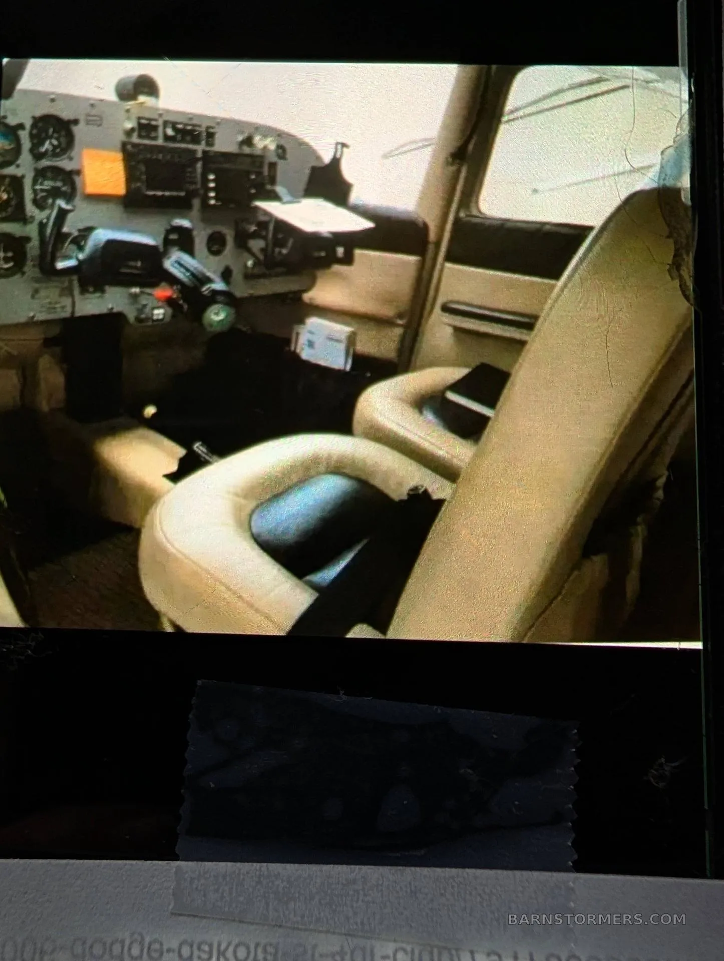 The tan leather seats and part of the instrument panel in the interior cabin of a small aircraft.