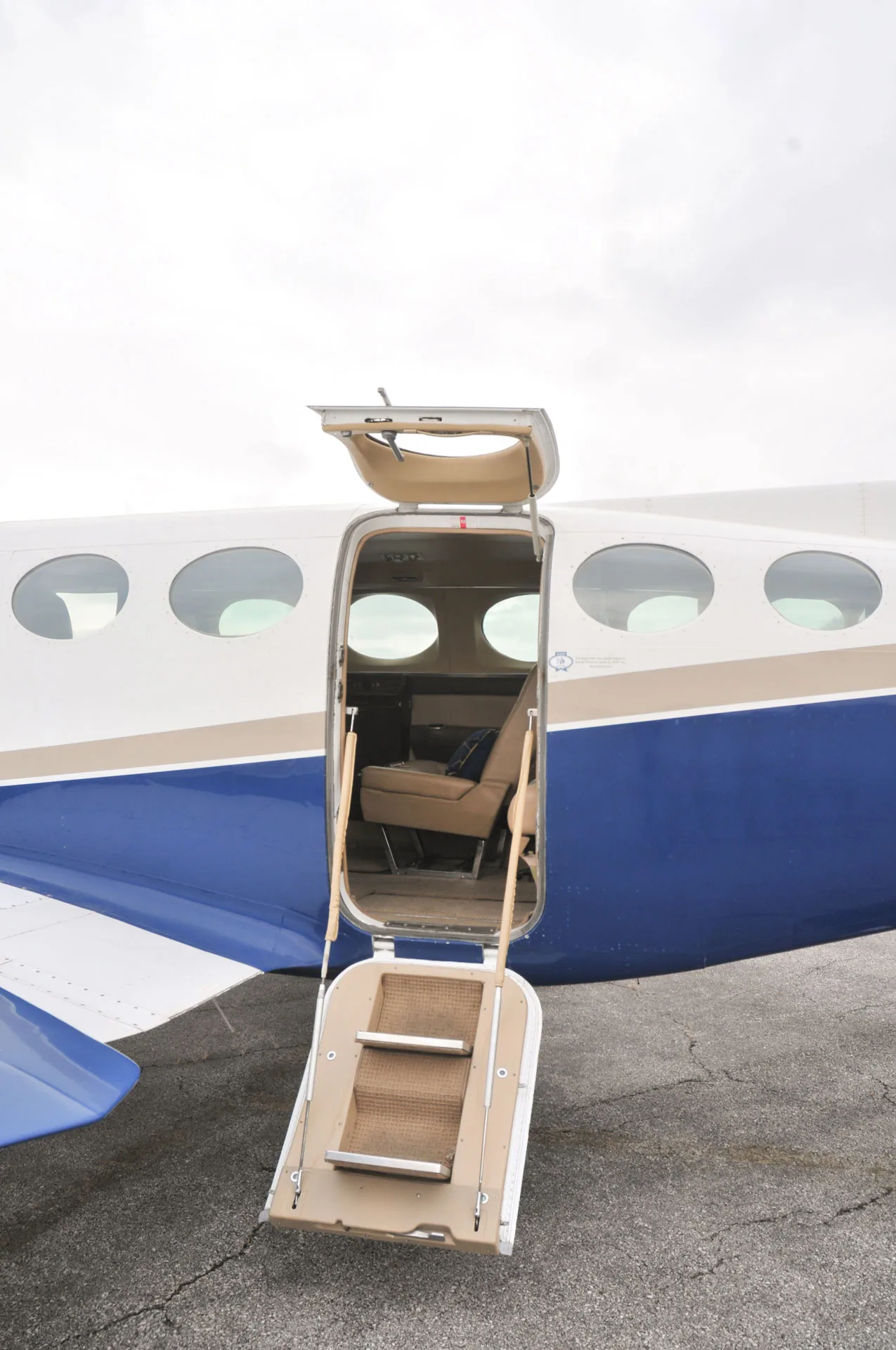 The open passenger door with integrated stairs of the N721HB aircraft, revealing a glimpse of the cabin interior.