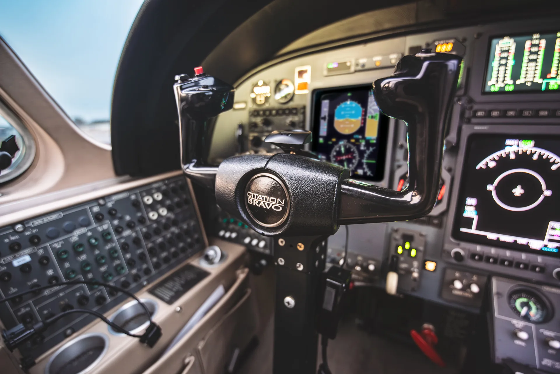 The cockpit of a Citation Bravo aircraft, showing the control yoke and instrument panel.