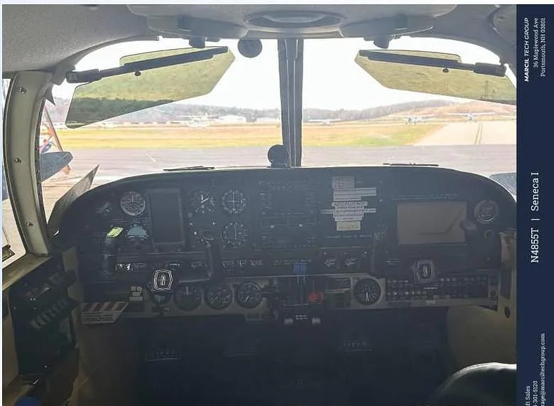 The cockpit instrument panel of a Piper Seneca I aircraft, showing various gauges and screens.