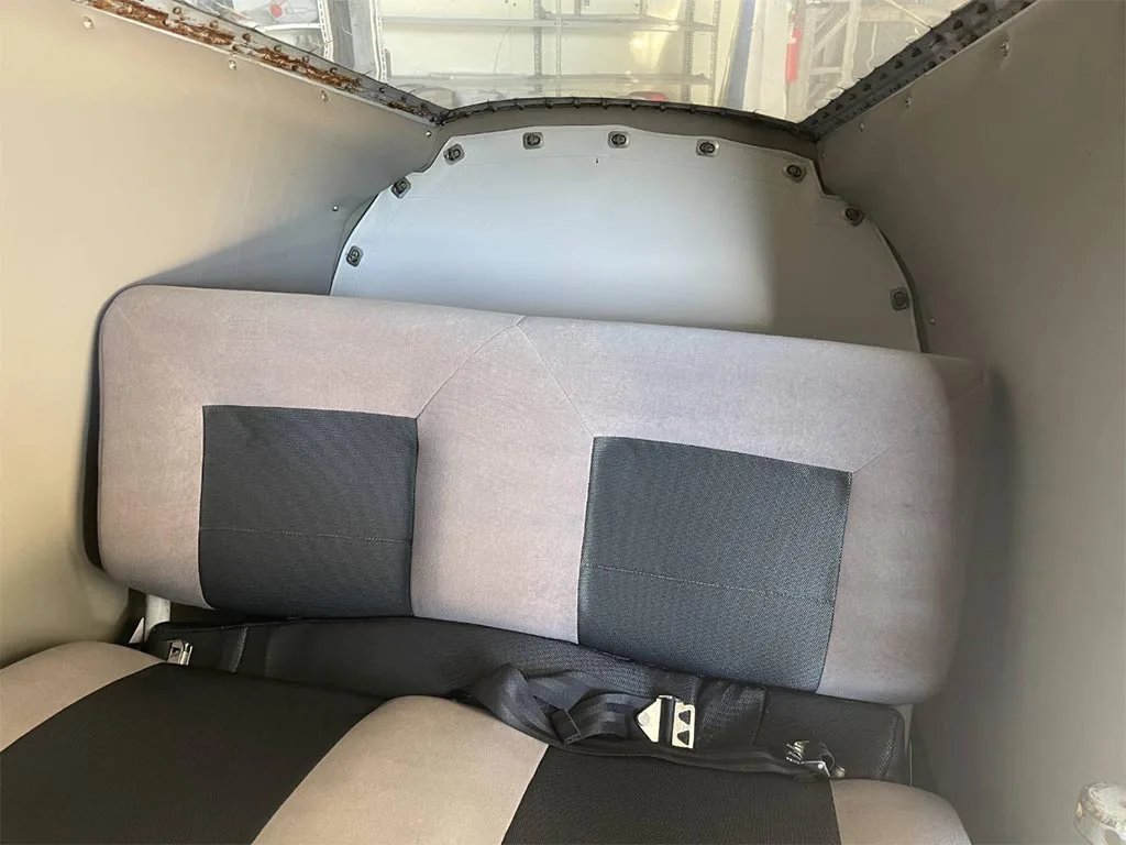 The rear cabin seats of an aircraft, upholstered in grey and black fabric.