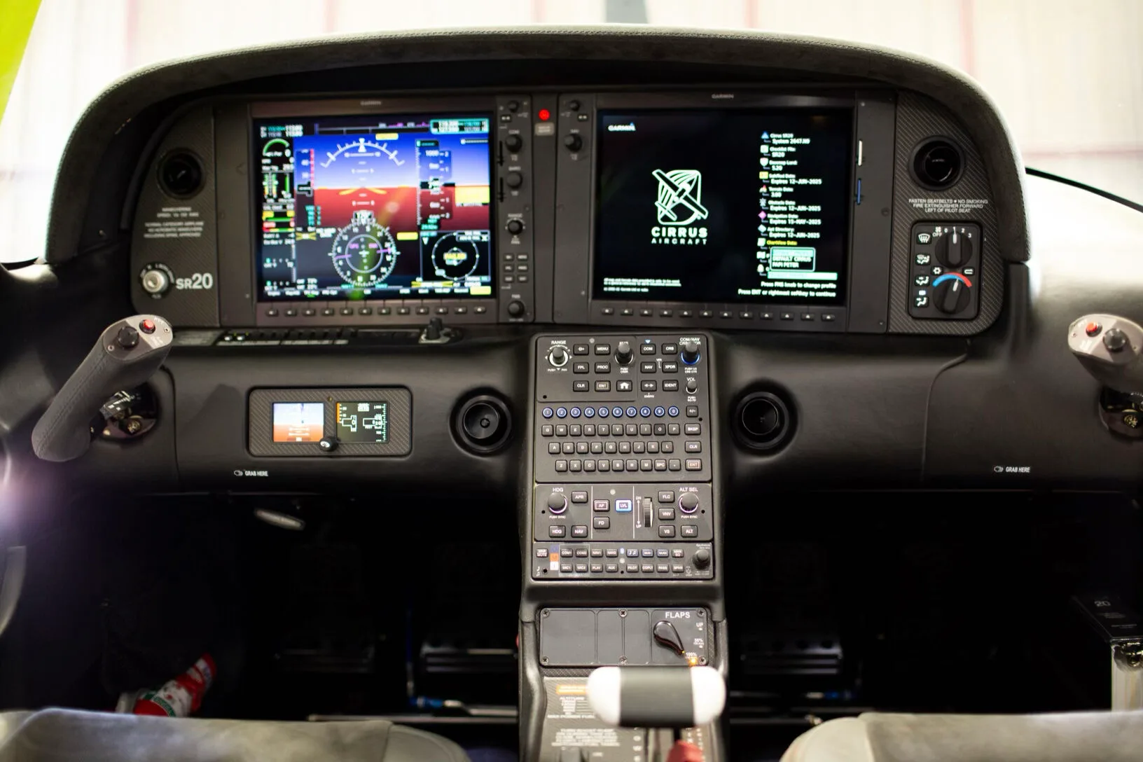 Close-up of the Cirrus SR20 instrument panel with dual Garmin screens and central control unit.