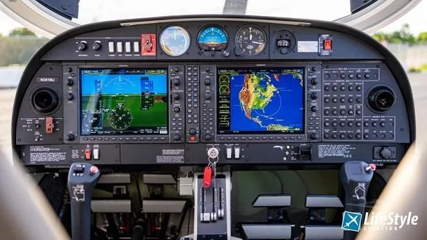 The cockpit of a Diamond DA40 aircraft, featuring a modern glass panel with two large display screens and traditional gauges.