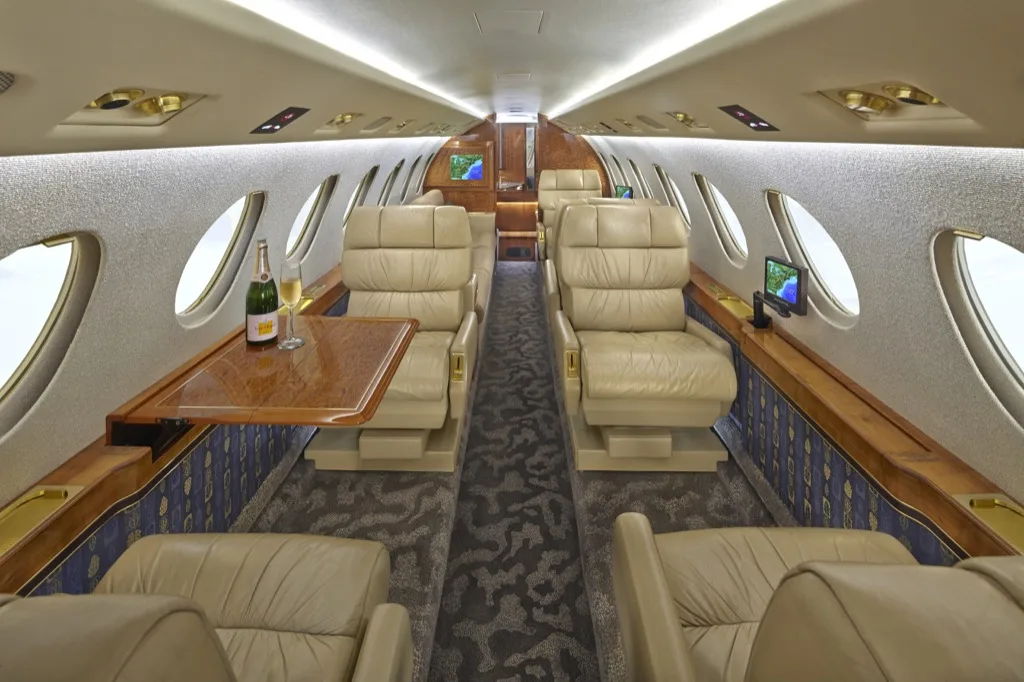 Hawker 850XP cabin interior with leather seats and wood trim.