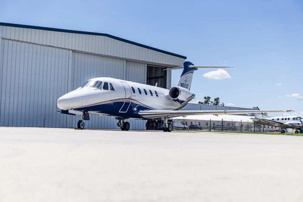 A side-front view of the white and blue Cessna Citation III business jet, N650AT, parked on an airfield.