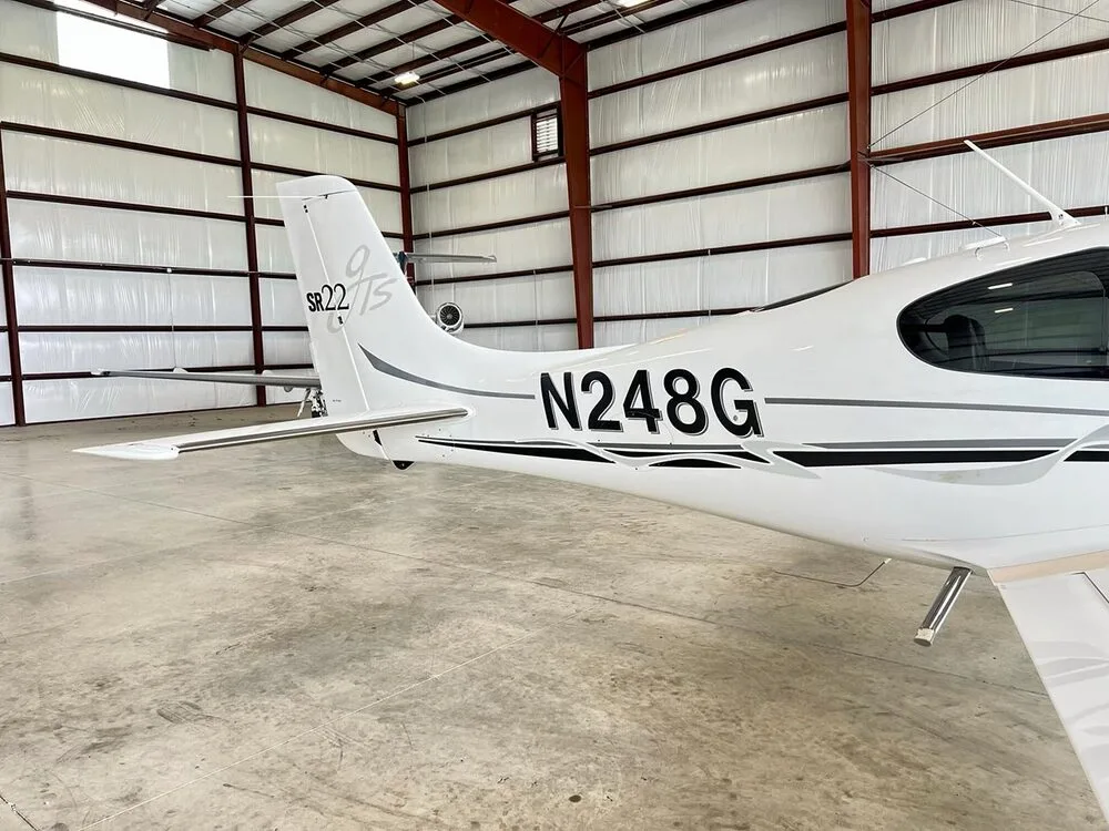 A close-up view of the tail section of a white Cirrus SR22 aircraft with registration N248G.