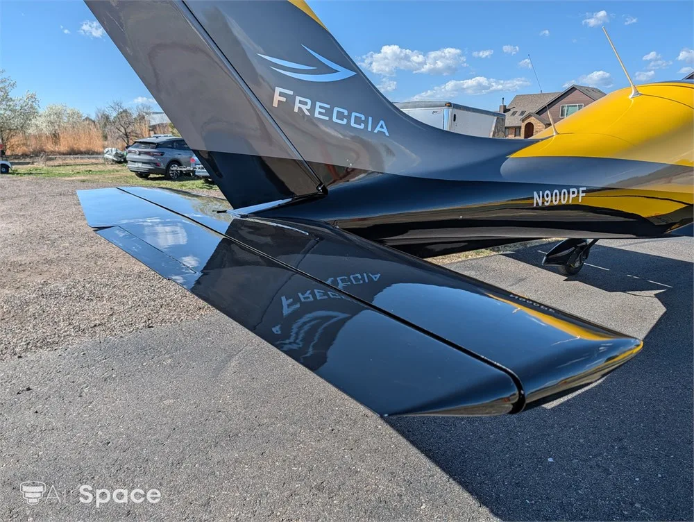 A close-up view of the black and yellow tail section of a Freccia F200 aircraft with N900PF visible.