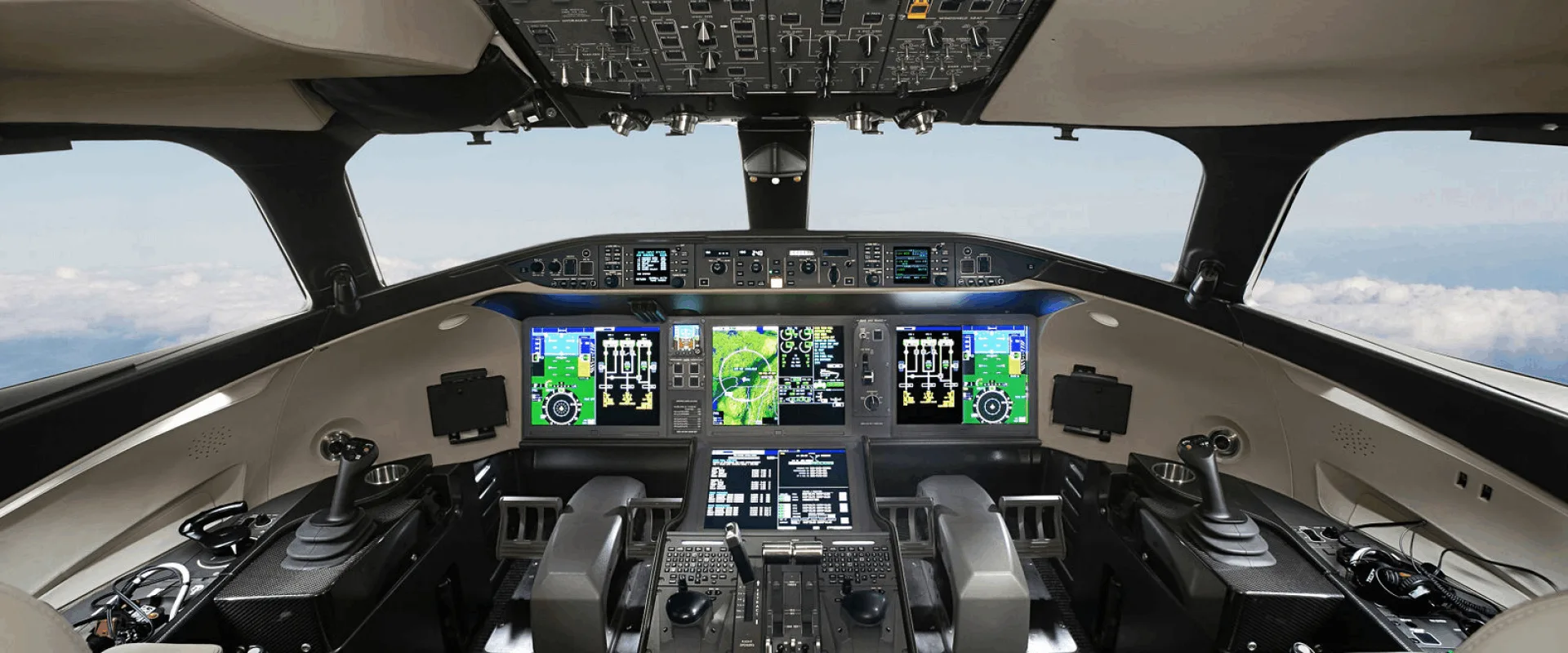 The modern cockpit of a business jet features multiple large digital displays and advanced flight controls.