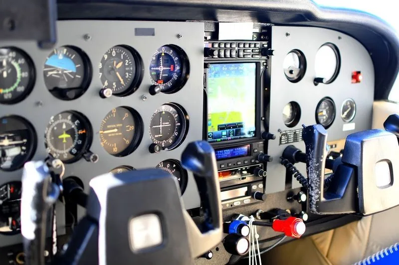 The instrument panel of a light aircraft, featuring analog gauges and a modern digital display.