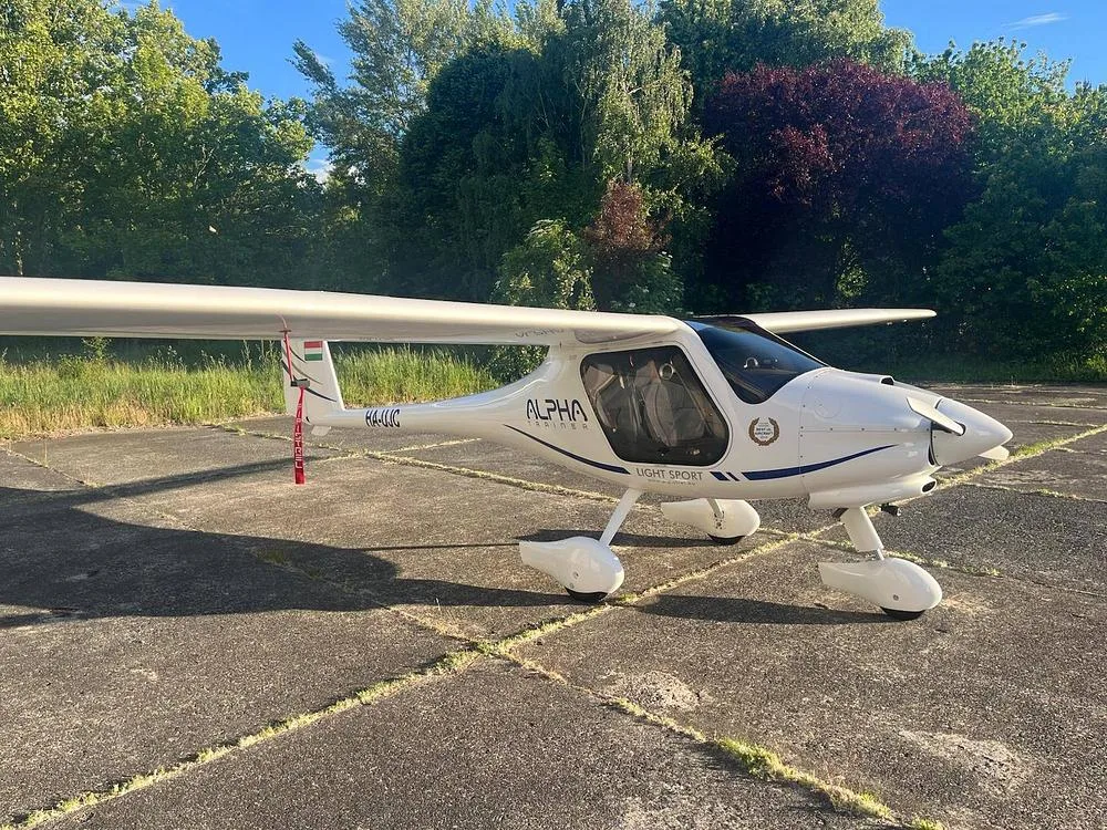 A white Alpha Light Sport aircraft with registration HA-LUC, parked on a concrete surface.