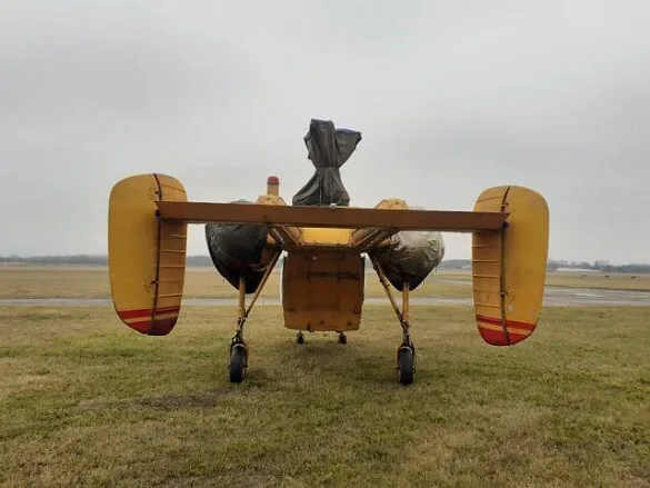 Rear view of a KAMOV Ka-26 helicopter with tarps on its rotors.