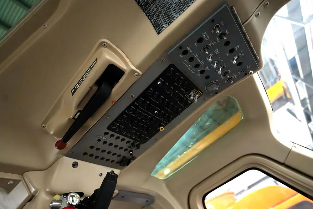 An overhead panel in the helicopter cockpit, featuring numerous switches and controls.