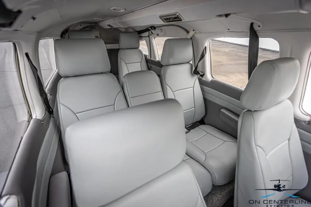 View of the cabin of a Piper PA-32R-301 Saratoga SP, featuring gray leather seats.