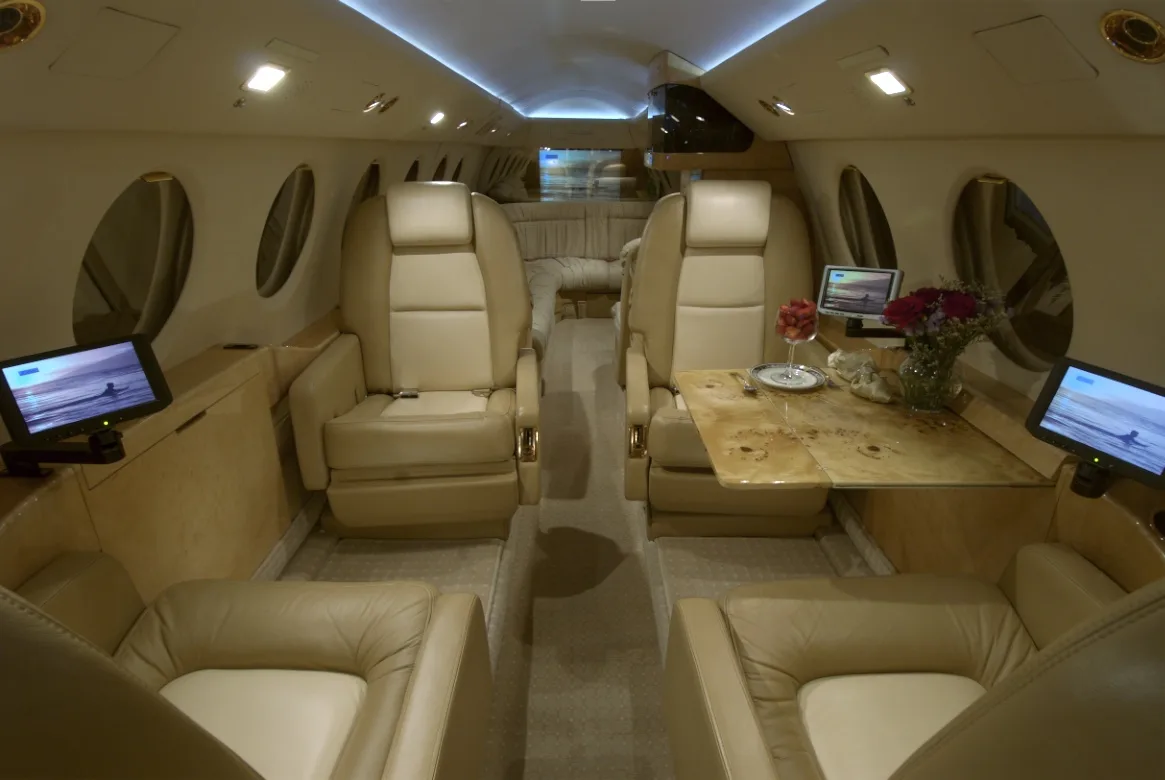 View of the aircraft's interior cabin with seats and a table.