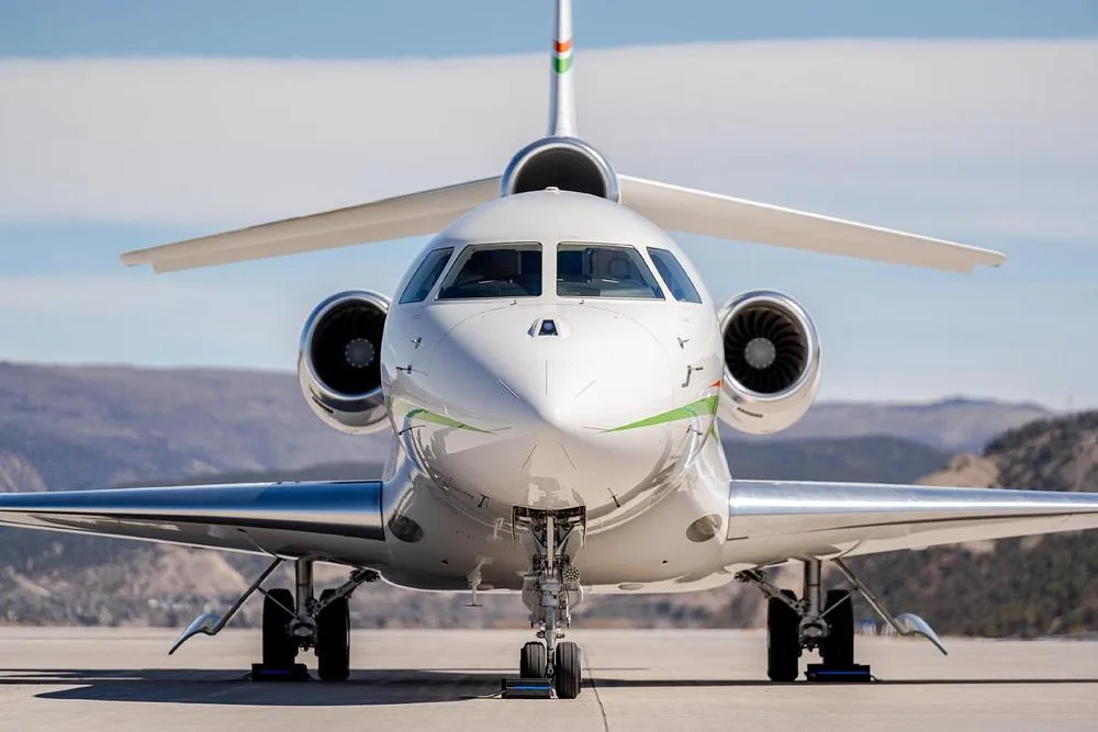 A head-on view of the white Dassault Falcon 900EX, registration N496AC, showing its nose and engines.