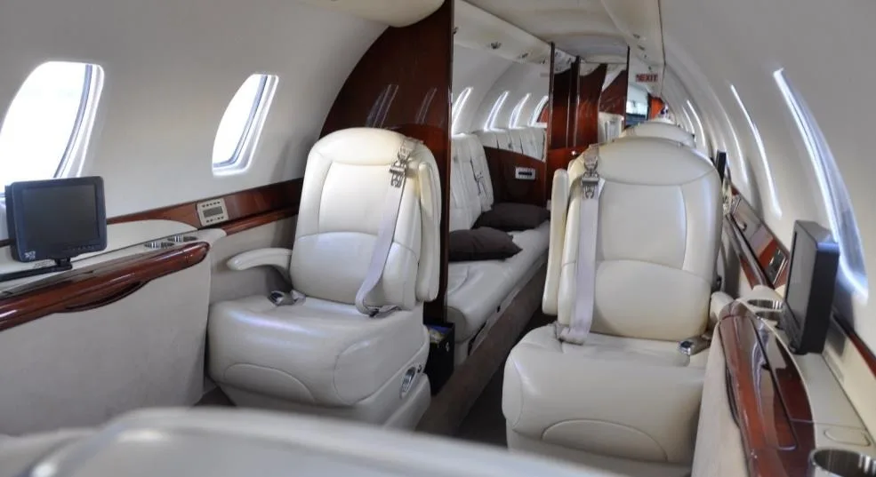 View of the aircraft interior with cream-colored leather seats.