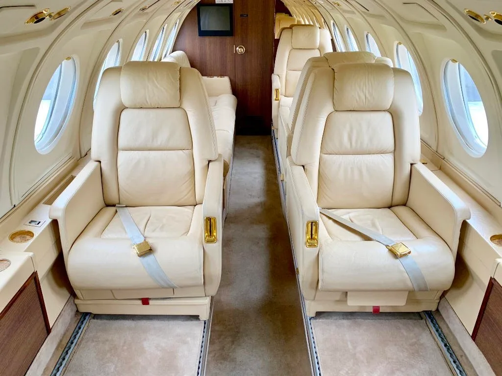 A view of the aircraft's interior with cream-colored leather seats.