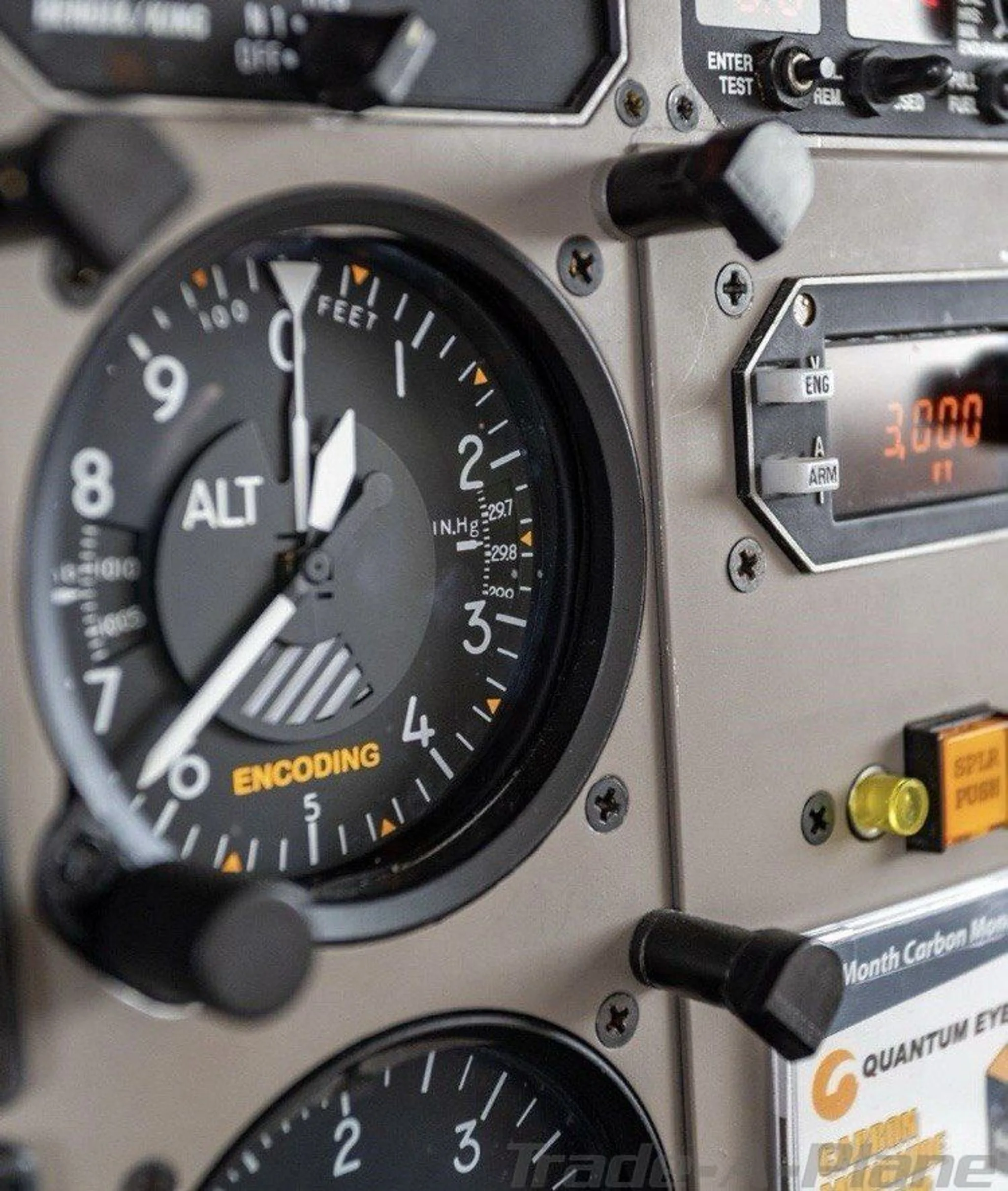 A close-up view of an aircraft altimeter and other cockpit instruments.