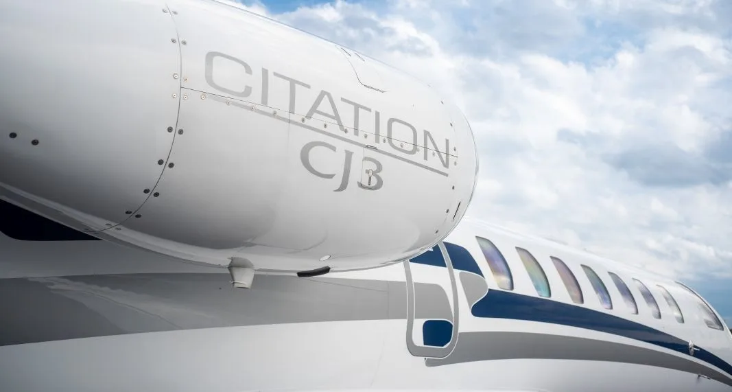 A close-up view of the engine and fuselage of a white Cessna Citation CJ3, showing the "CITATION CJ3" text and blue stripe.