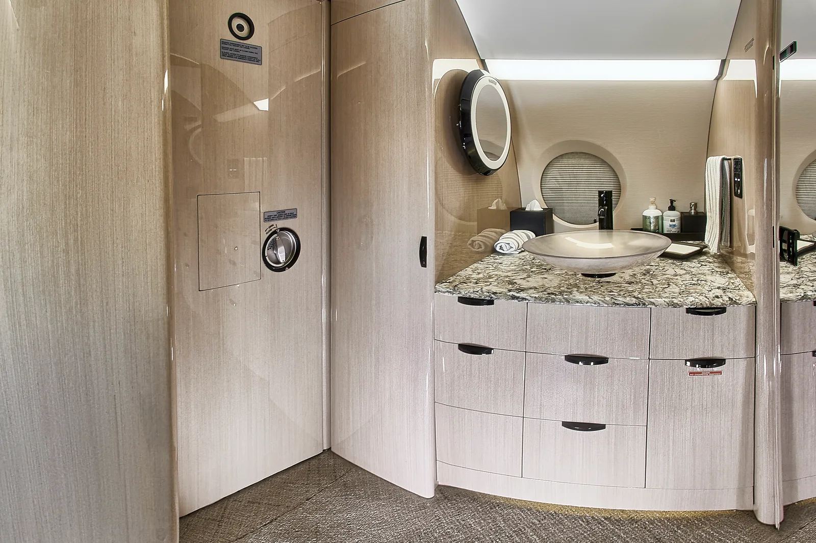 Aircraft lavatory with marble countertop and sink.