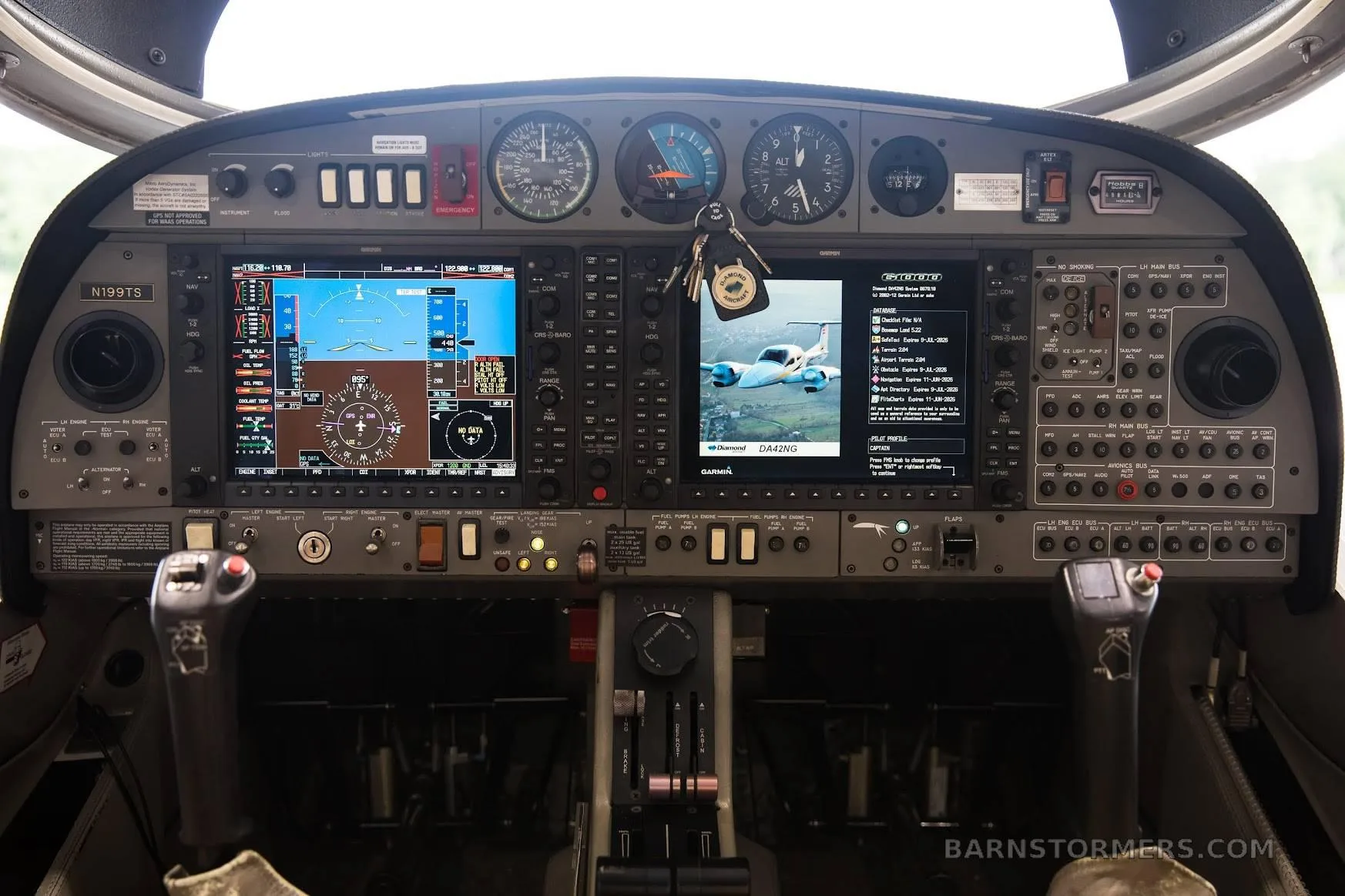 The cockpit of a Diamond DA42 aircraft, showing the instrument panel with large digital displays and analog gauges.